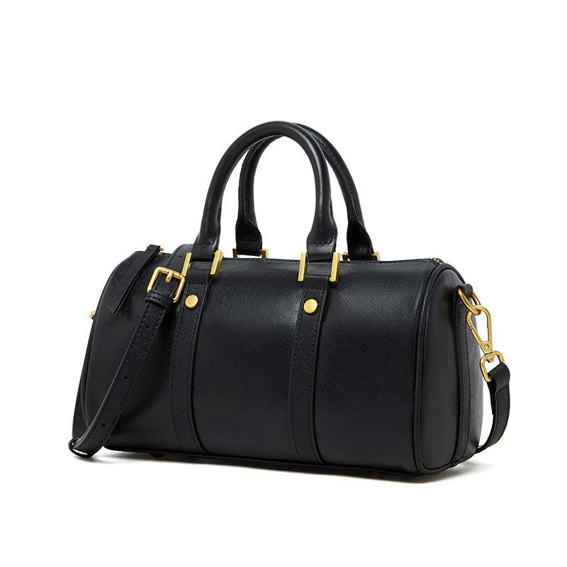 Classic leather barrel handbag with gold hardware and adjustable strap.