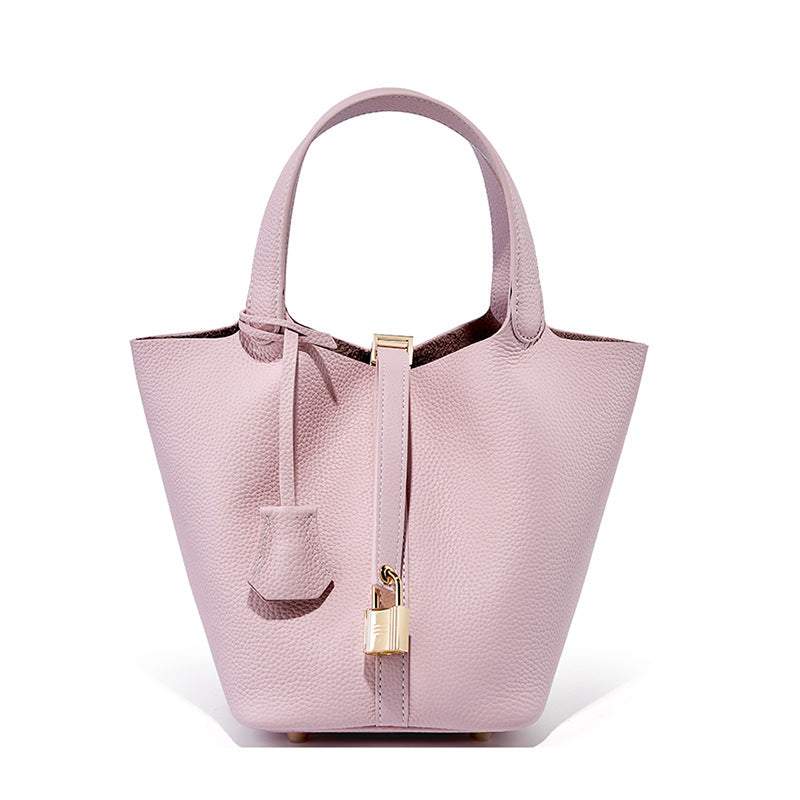 Pink Lychee Leather Basket Tote with a modern silhouette, durable genuine leather, and a signature lock.