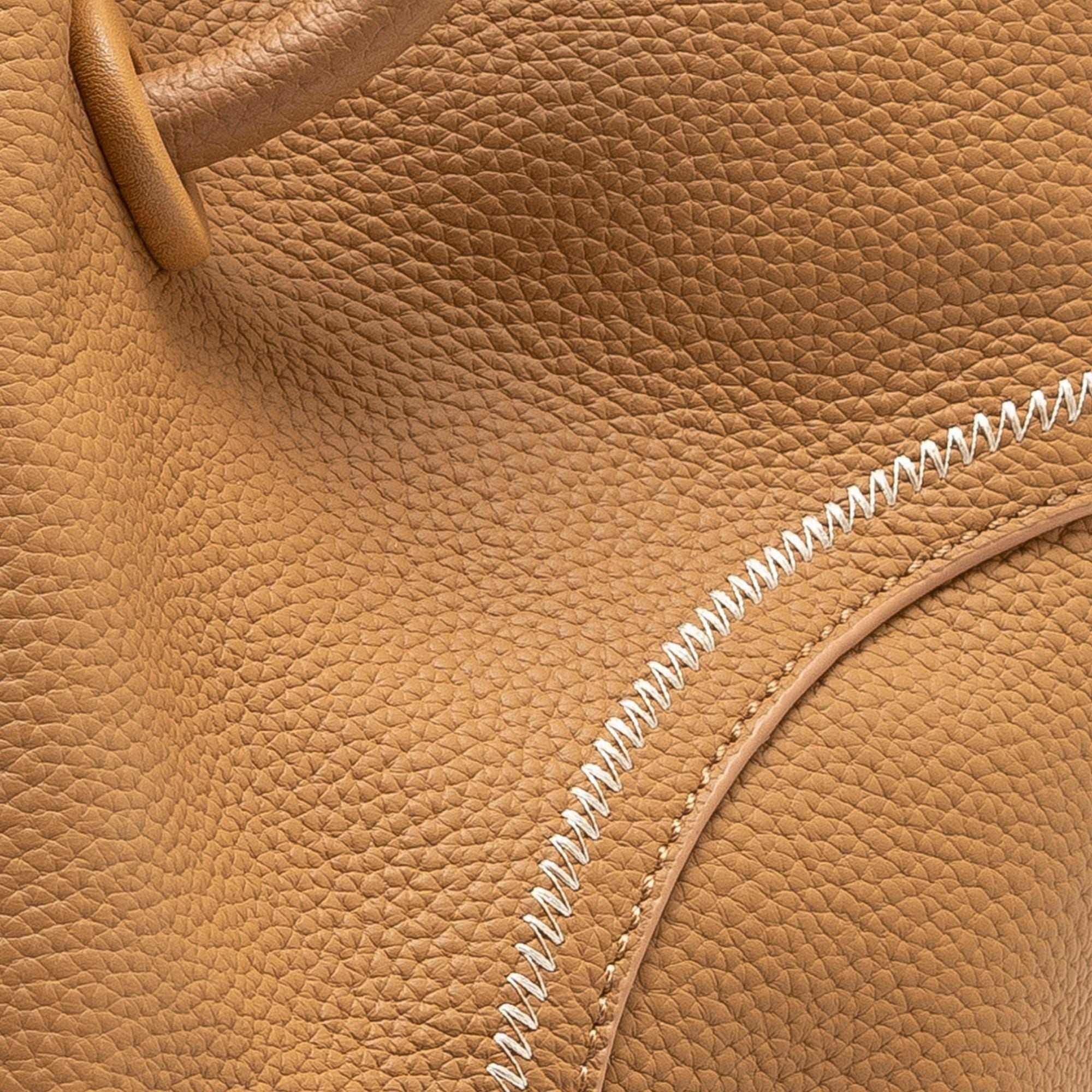 Leather crossbody bucket tote in full-grain lychee leather with circular handles and removable pouch