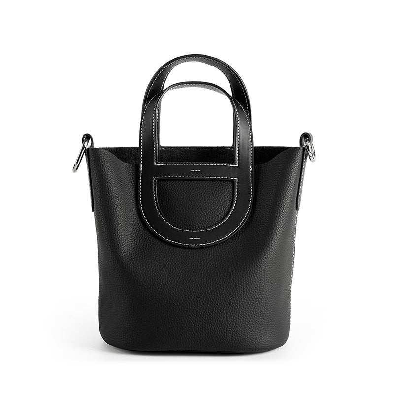 Sleek leather bucket handbag with lychee-pattern design, removable interior, and shoulder strap.
