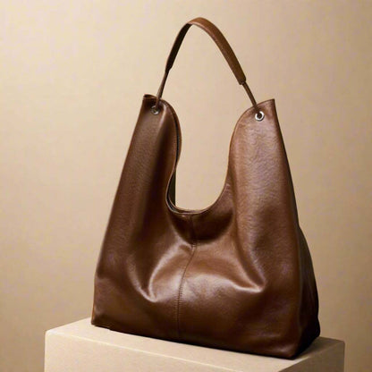 Brown leather hobo slouch purse on display, highlighting its elegant design and large capacity.