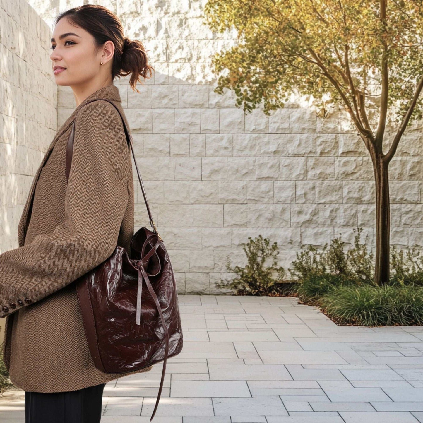 Woman wearing a Burgundy Bucket Bag made of genuine leather.