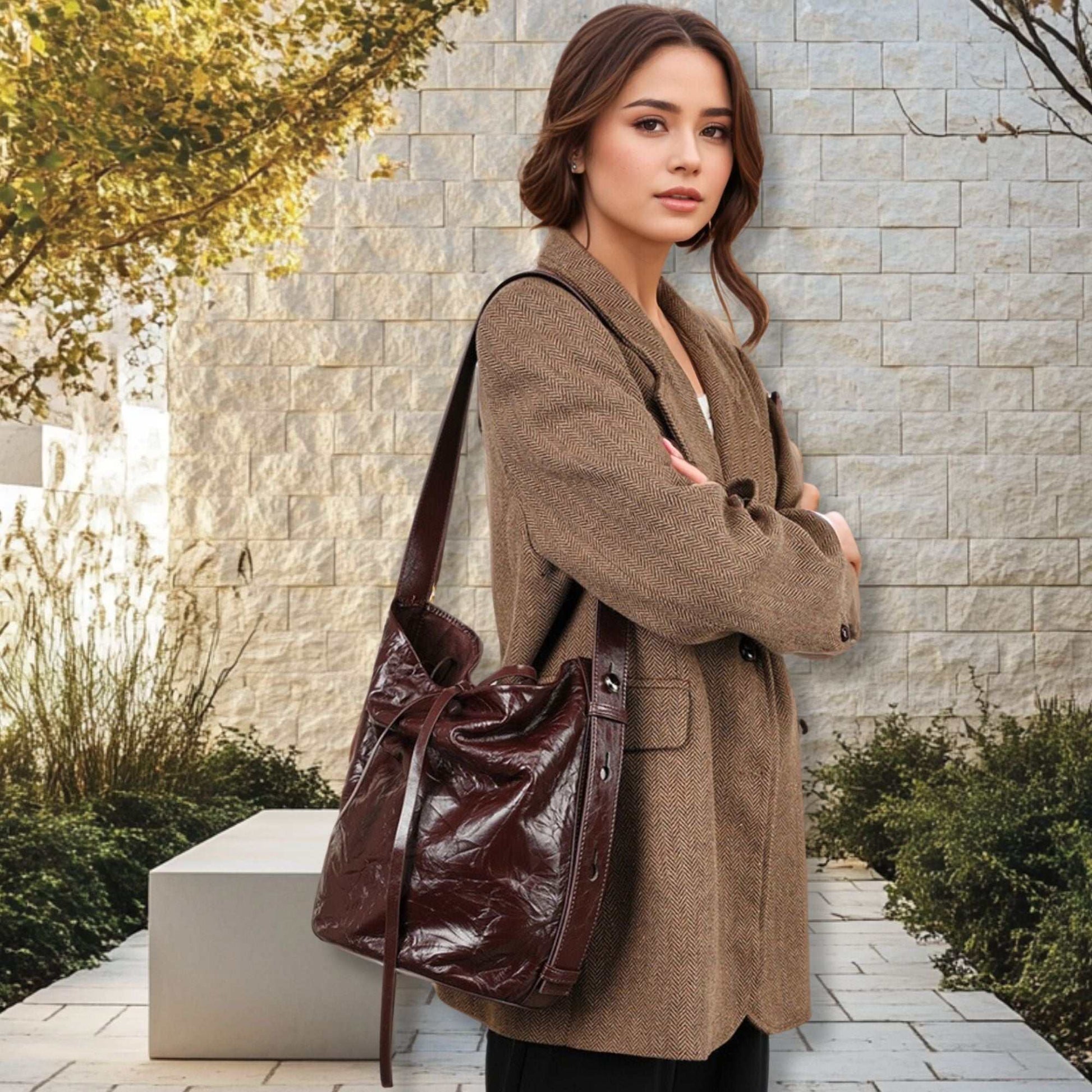 Woman carrying Burgundy Bucket Bag made from genuine leather, featuring a stylish wrinkled pattern, perfect for everyday use.