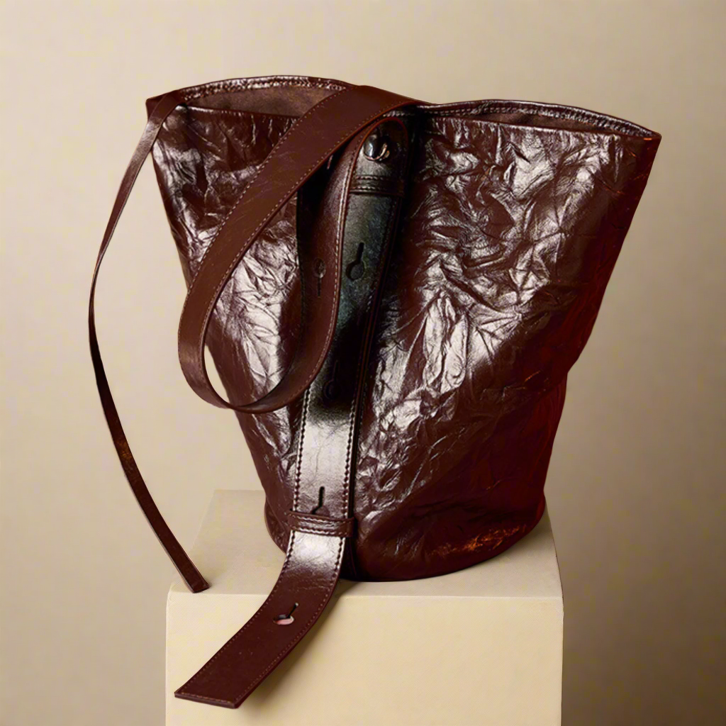 Luxurious burgundy bucket bag made from genuine leather with a unique wrinkled pattern and tie closure.