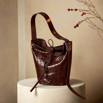 Burgundy Bucket Bag with elegant wrinkled leather design on display.