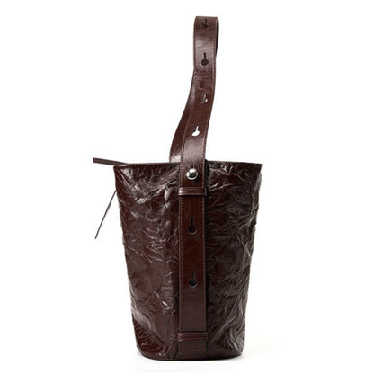 Burgundy bucket bag with wrinkled leather and adjustable strap.