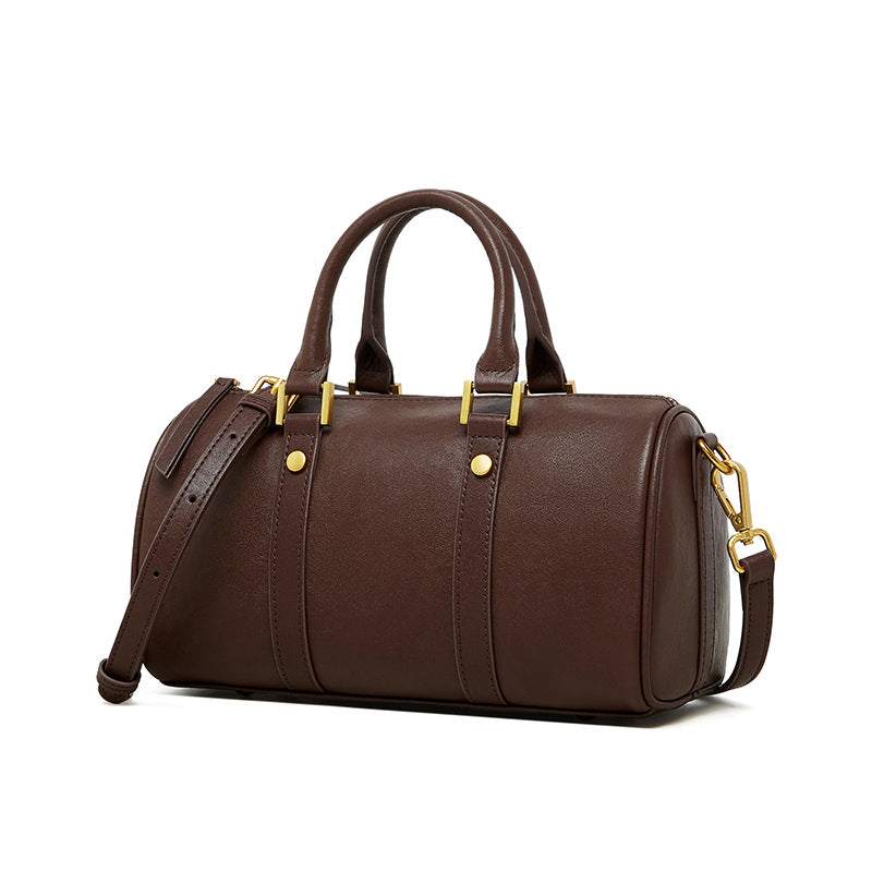 Classic leather barrel handbag with gold hardware and adjustable strap.