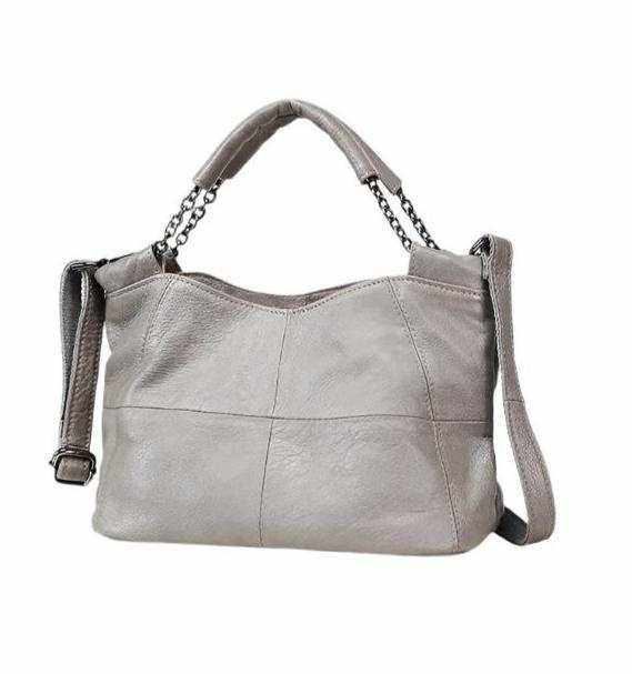 Cross body soft leather bag with chain-link handle and adjustable strap, featuring decorative stitching.