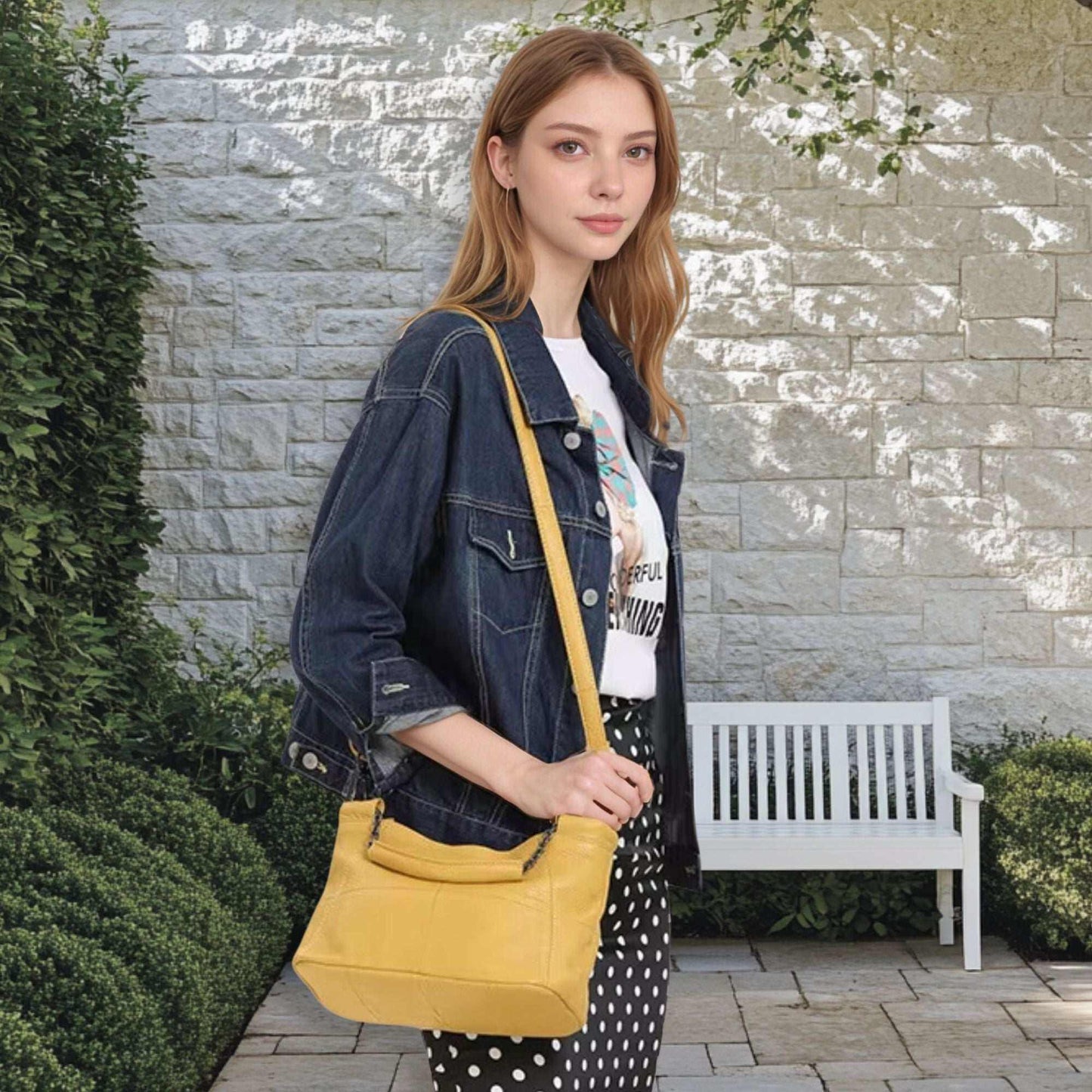 Woman holding a yellow crossbody soft leather bag.