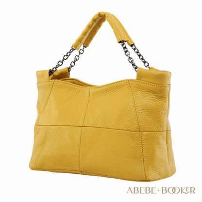 Yellow crossbody soft leather bag with chain-link handles and decorative stitching.