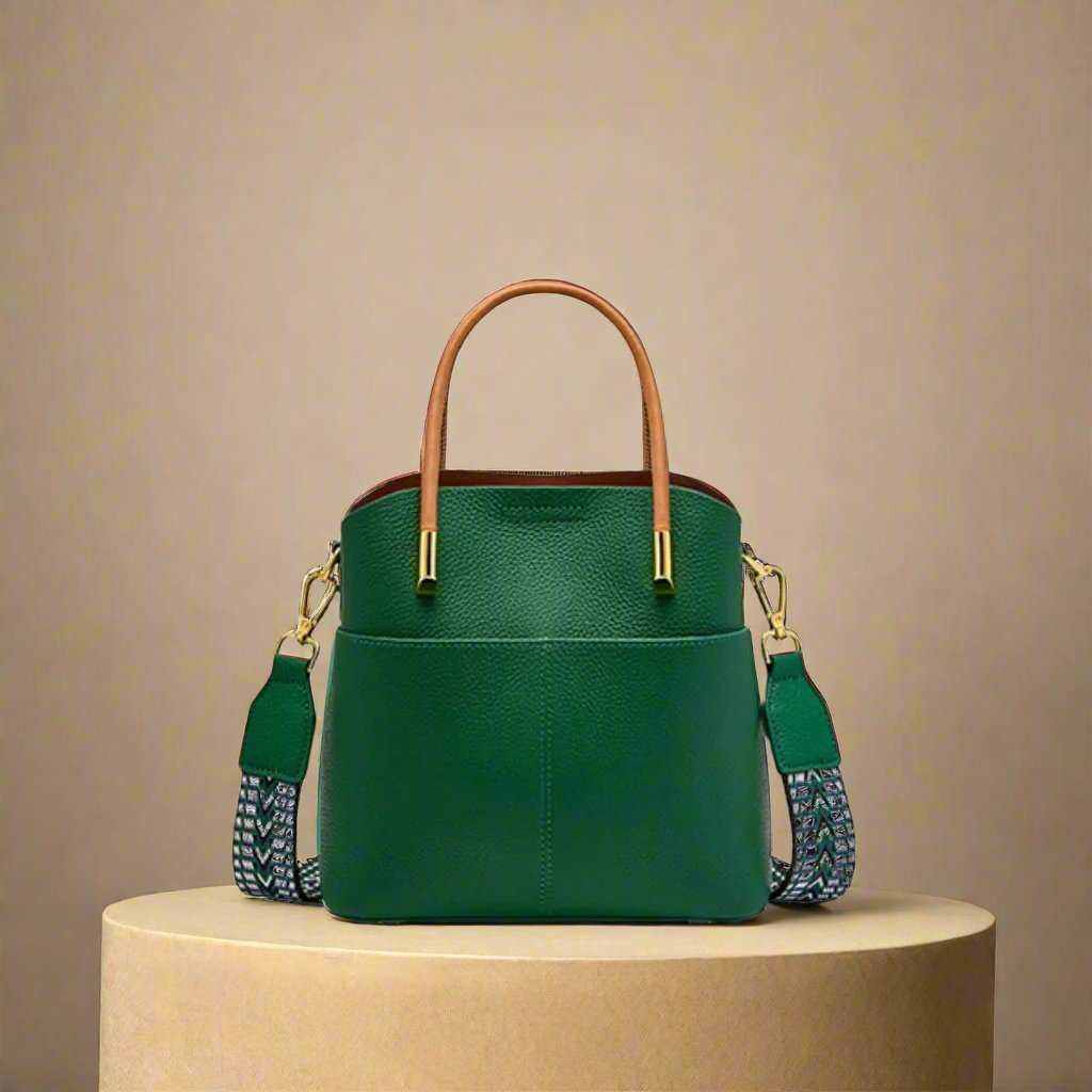 Green crossbody bucket handbag with leather finish and interchangeable straps.