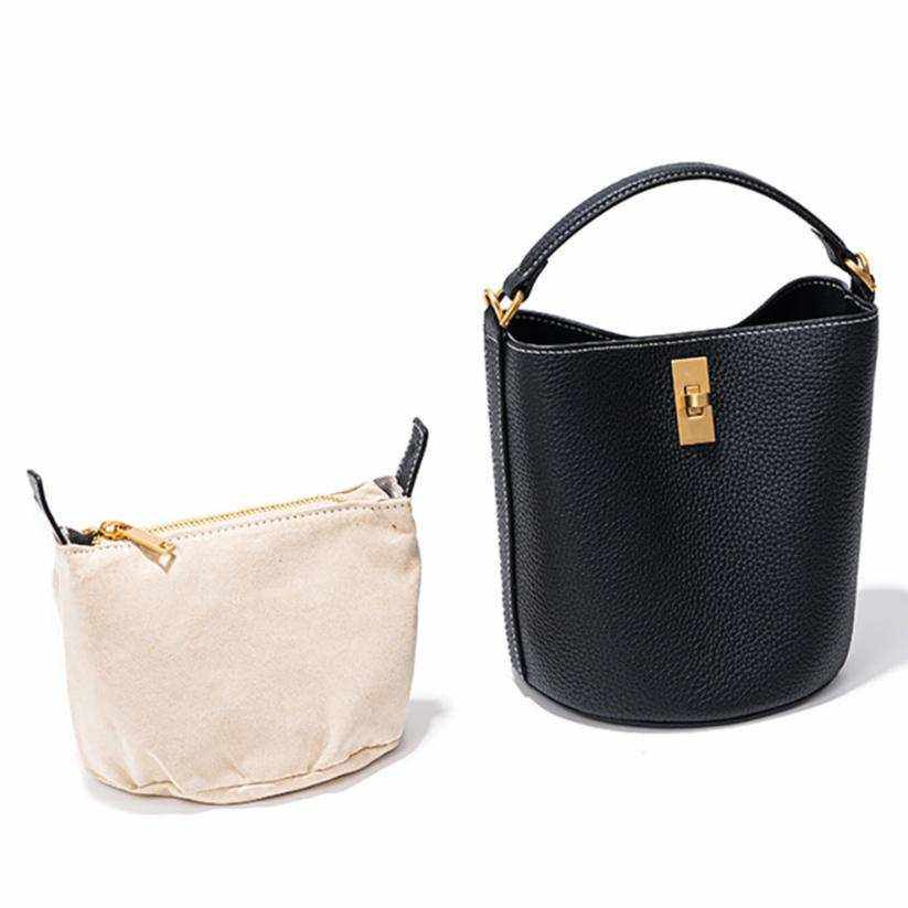 Crossbody bucket purse with black leather exterior and removable beige lining.