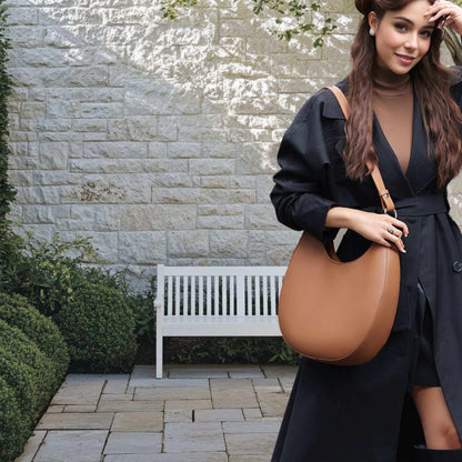 Woman wearing a Crossbody Saddle Purse crafted from premium leather, showcasing a chic and elegant style in an outdoor setting.