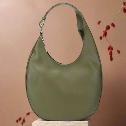 Green Crossbody Saddle Purse on Display Stand.