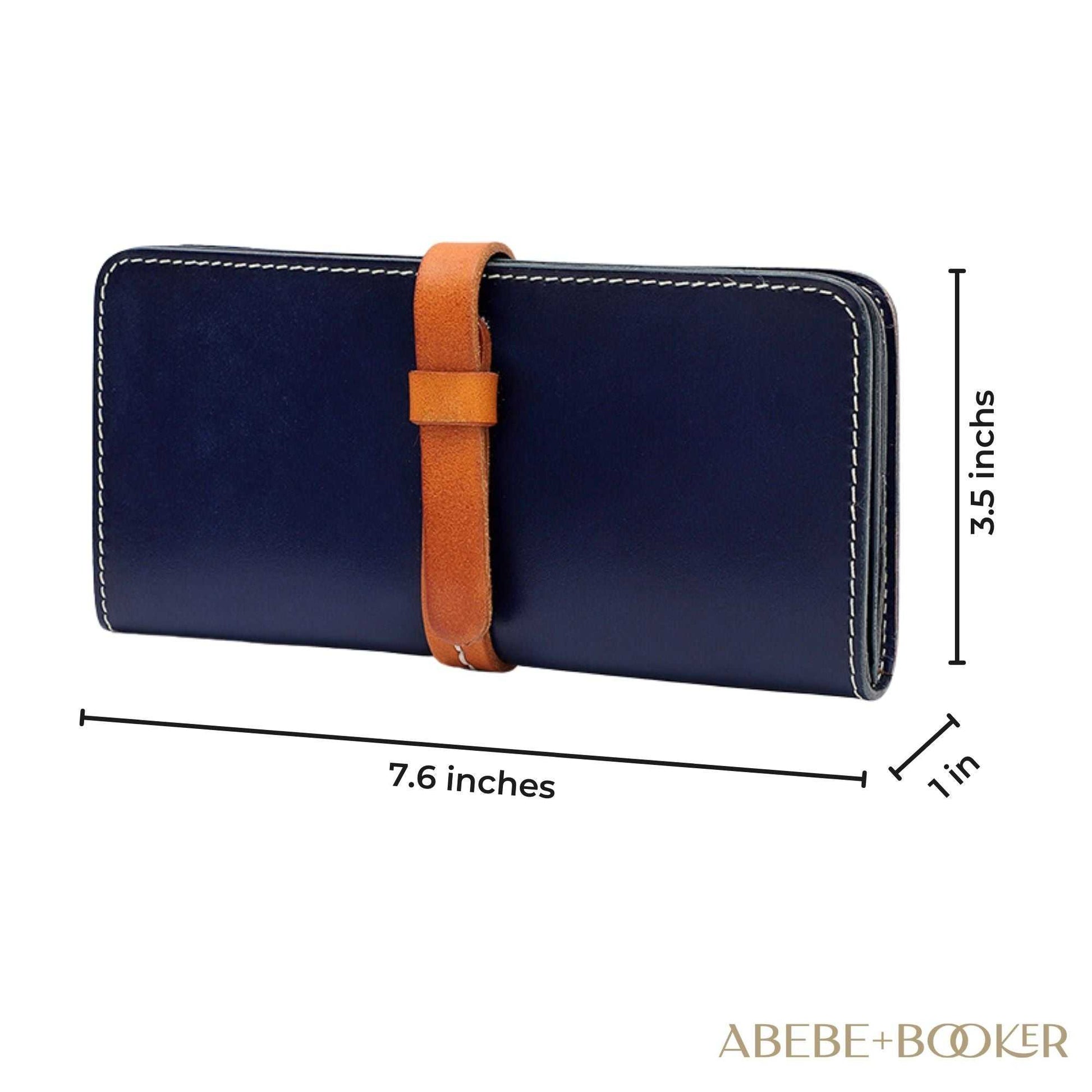 Female leather wallet with deep blue exterior and brown strap closure, compact design, made from genuine leather.