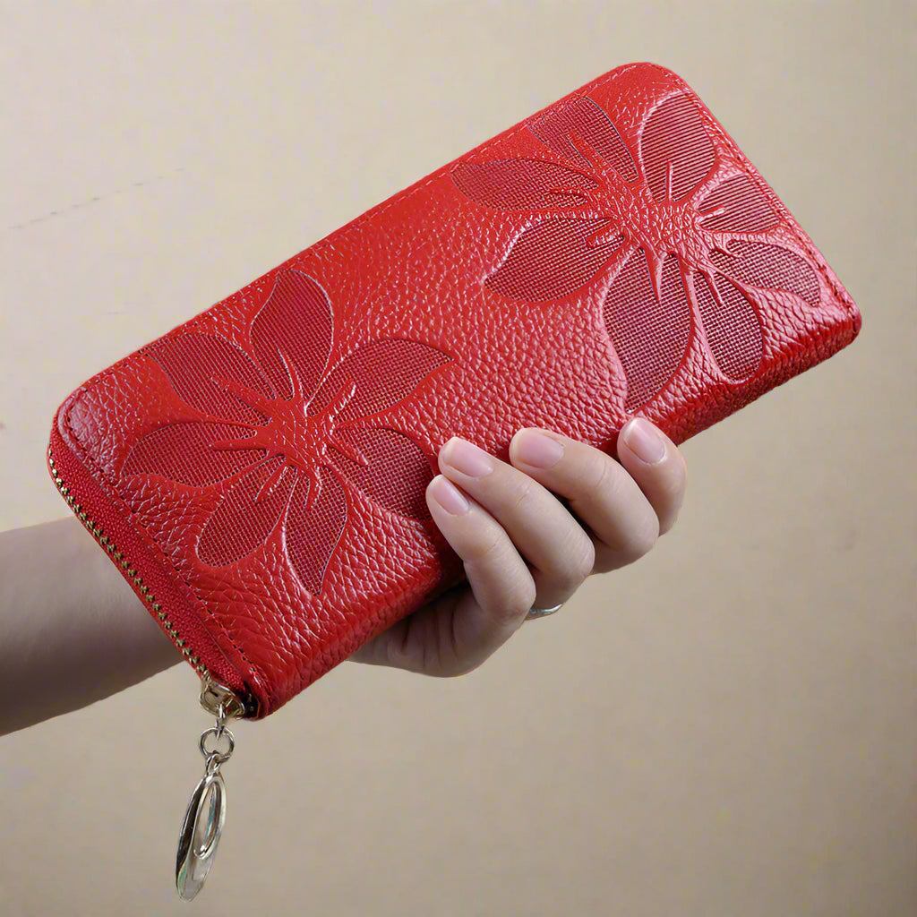 Red floral design leather wallet for women being held.