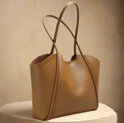 Ladies Leather Tote with rolled leather straps, sleek design, and spacious interior.