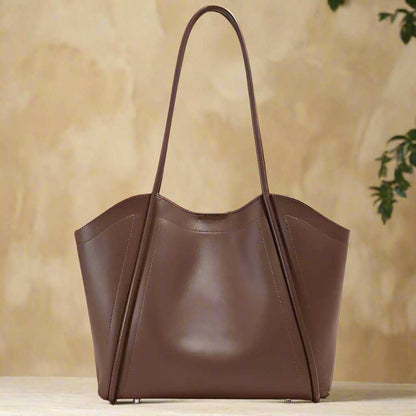 Ladies Leather Tote with sculpted lines and rolled leather straps, part of Essence of Elegance Collection.