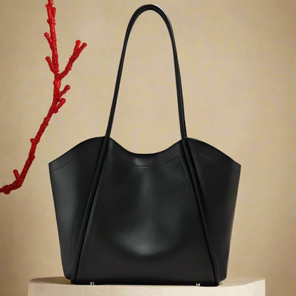 Ladies leather tote with sleek design and rolled straps.