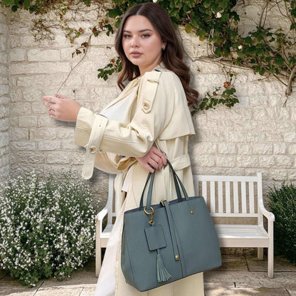 Woman holding a stylish Ladies Leather Work Bag with tassel in a garden setting.