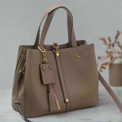 Ladies Leather Work Bag in taupe with removable tassel and adjustable shoulder strap, perfect for versatile use.