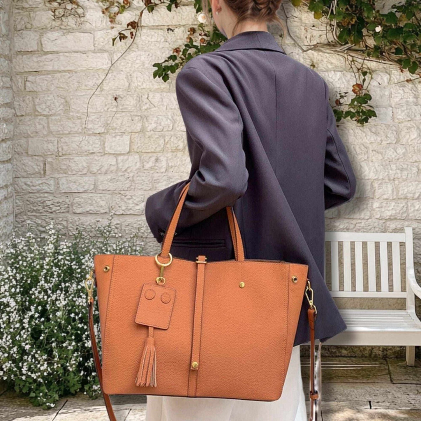 Elegant ladies leather work bag with tassel detail, perfect for versatile carrying.