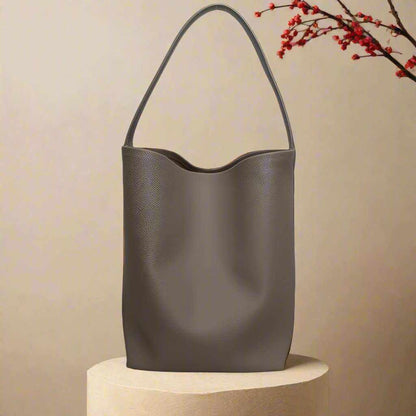 Iconic Leather Bucket Bag Lychee with chic design and spacious interior.