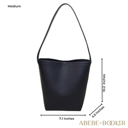 Medium-sized black leather bucket bag with handle, measuring 10.2" H x 7.1" L x 4.5" W from Abebe+Booker.