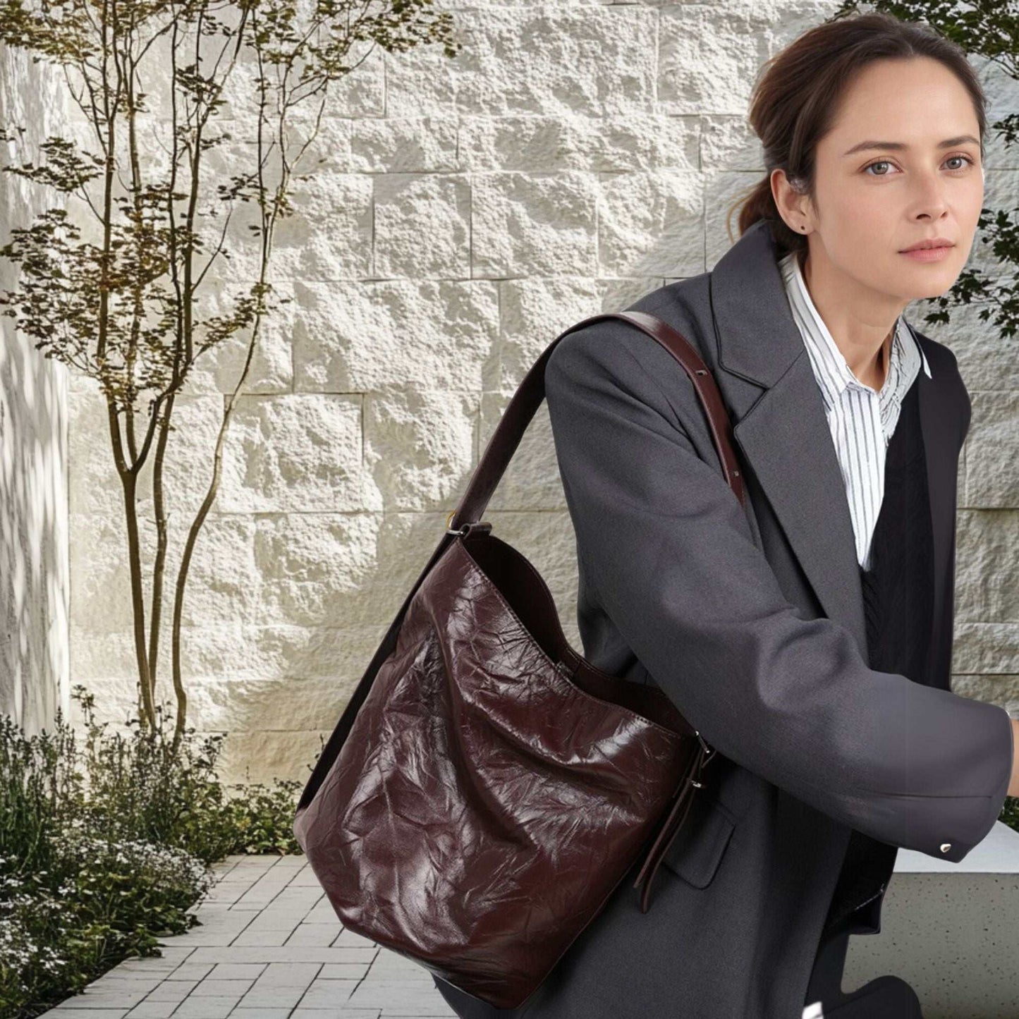 Leather Convertible Backpack from the Leather Bucket Handbags Collection, worn by a woman in a stylish outdoor setting.