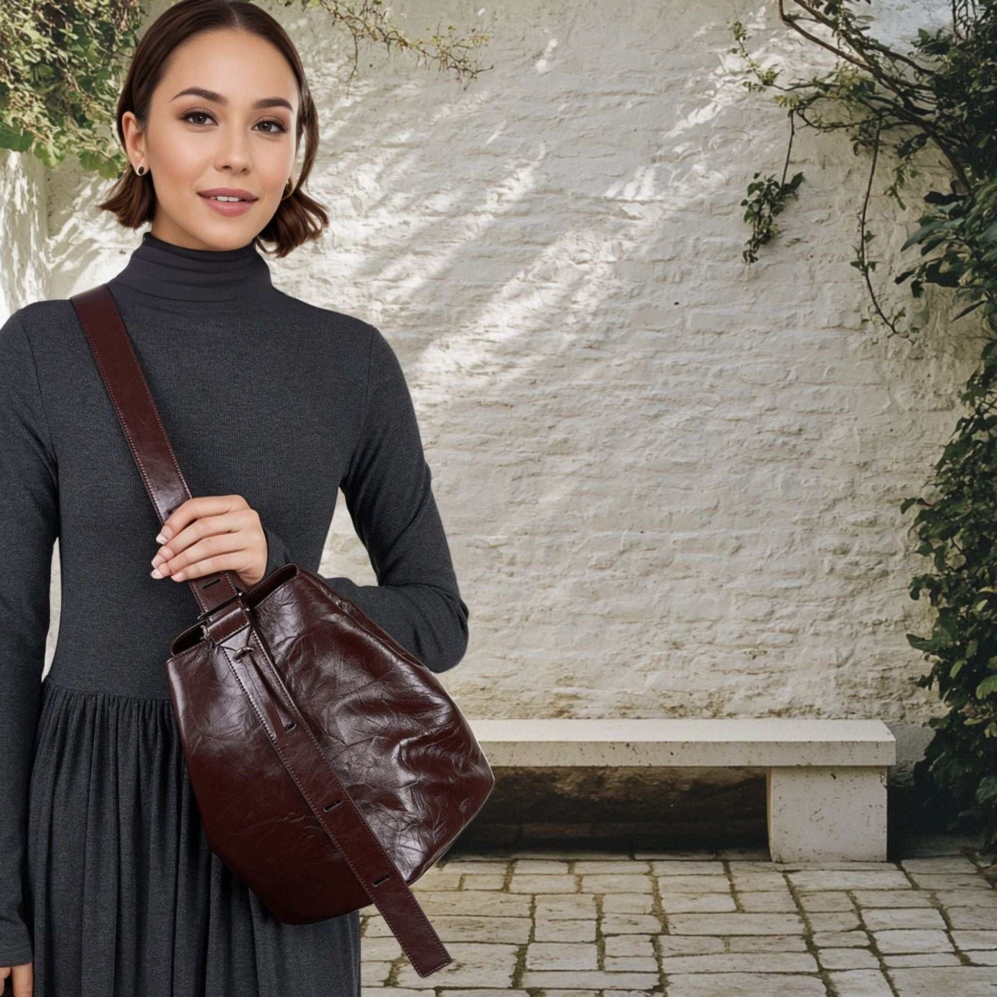 Woman wearing a leather convertible backpack in a garden setting.