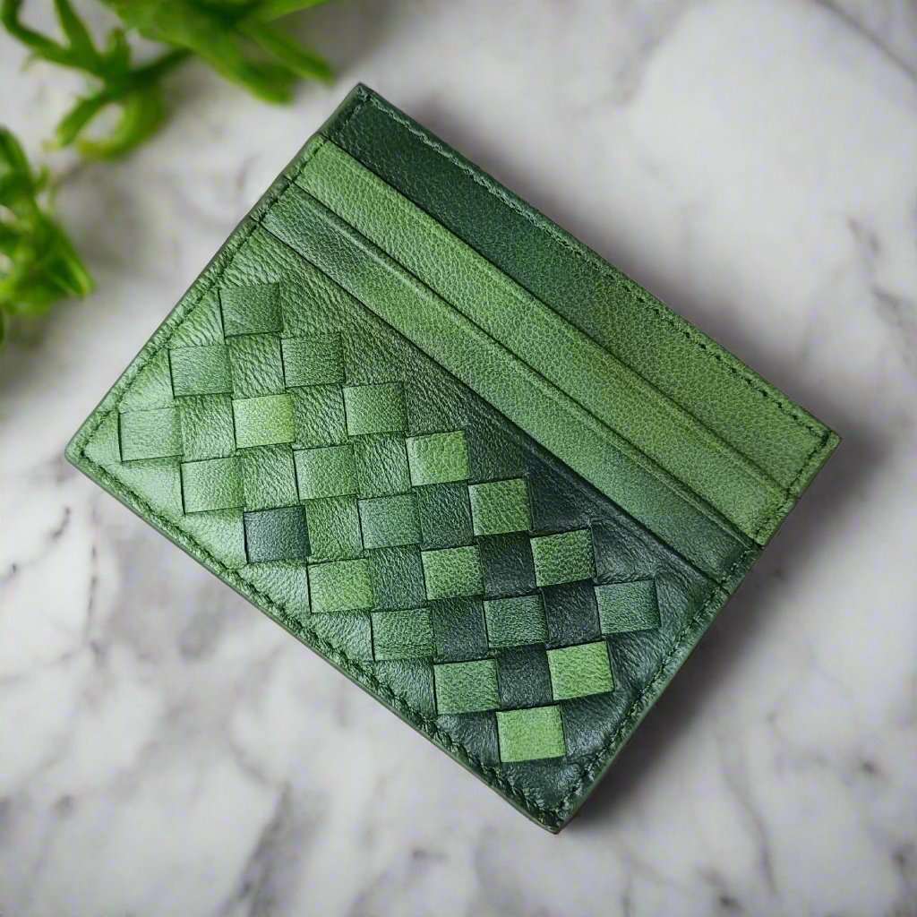 Green woven leather credit card carrier on marble background.