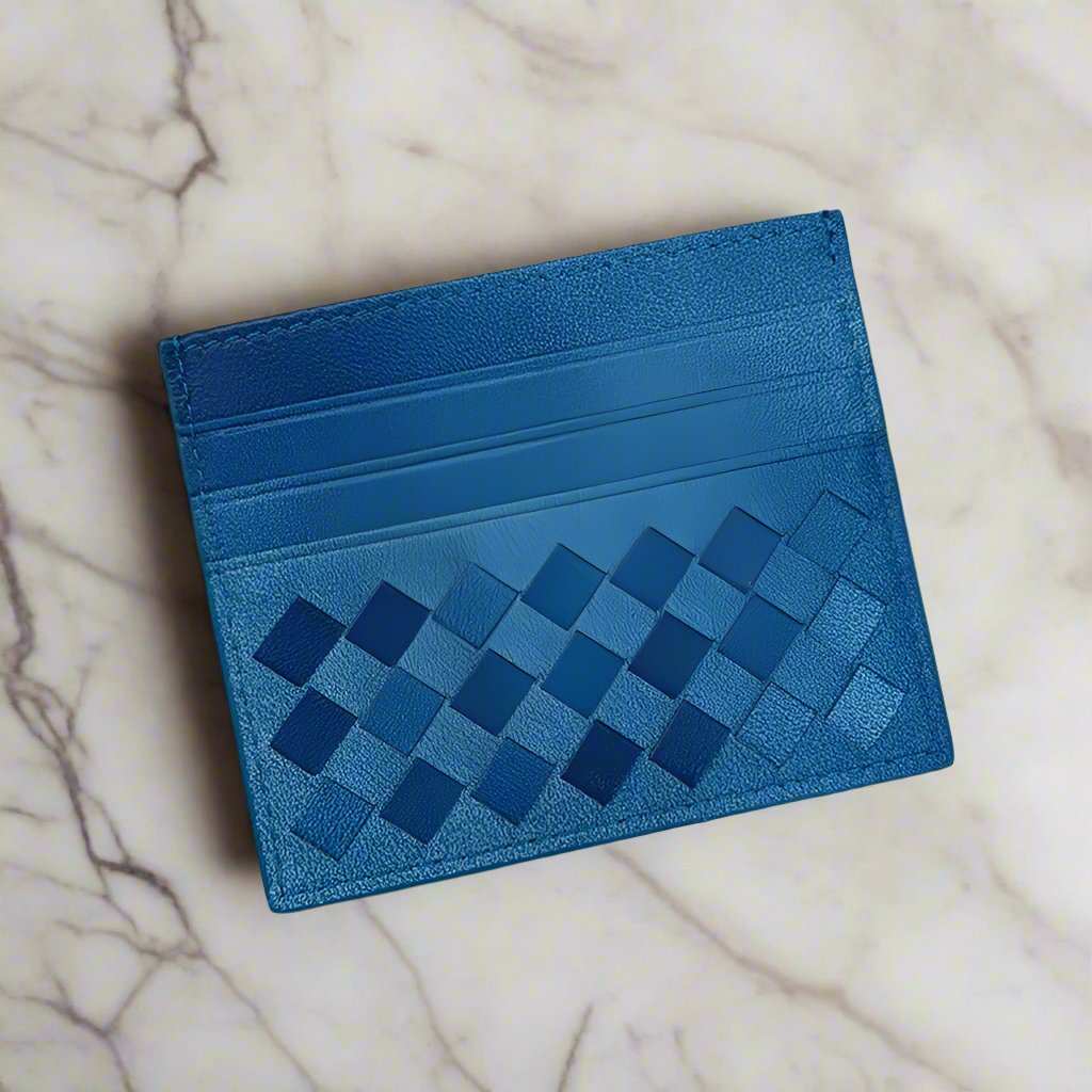 Blue woven leather credit card carrier on marble background.