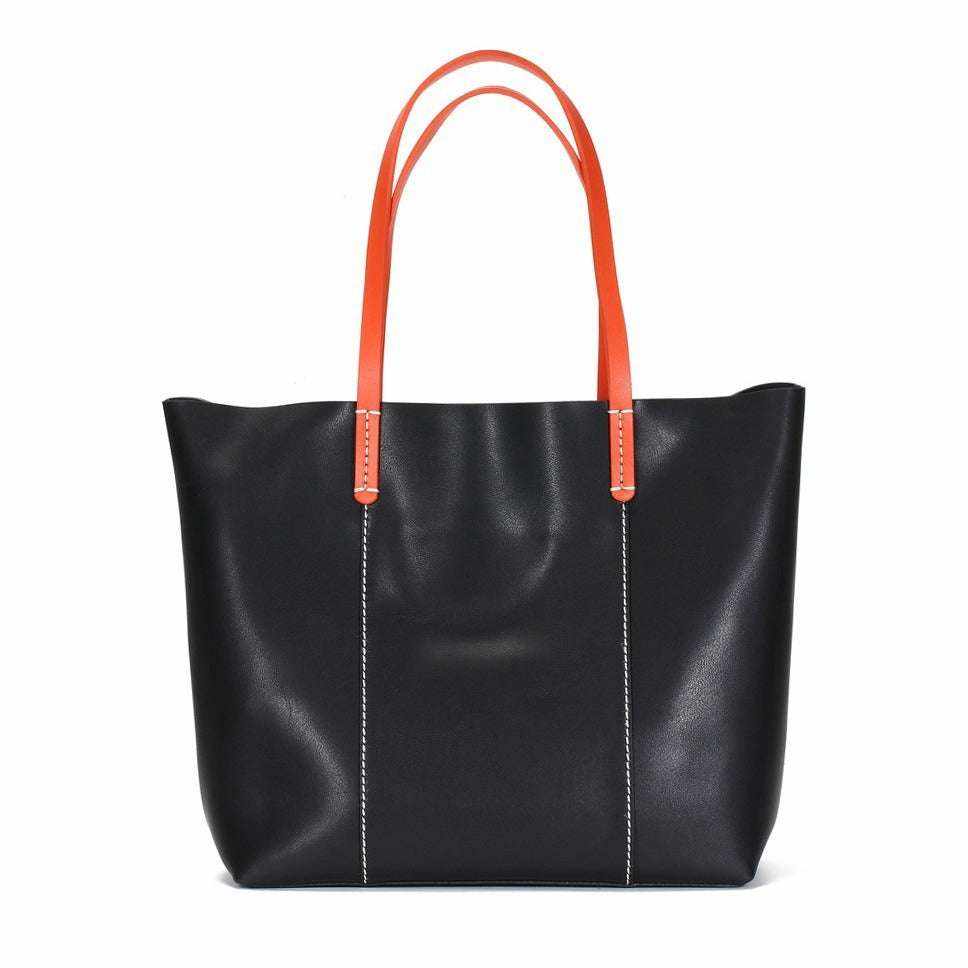 Leather handbag with vibrant navy body and carrot-colored straps from the Essence of Elegance Collection.