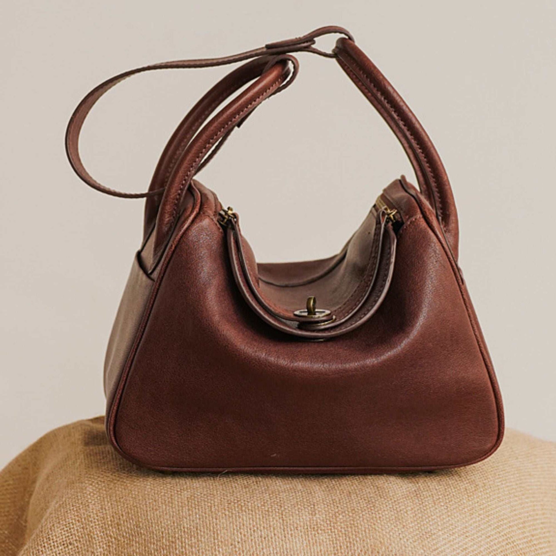 Leather satchel purse in brown, crafted from premium soft leather, featuring a spacious interior and adjustable strap.