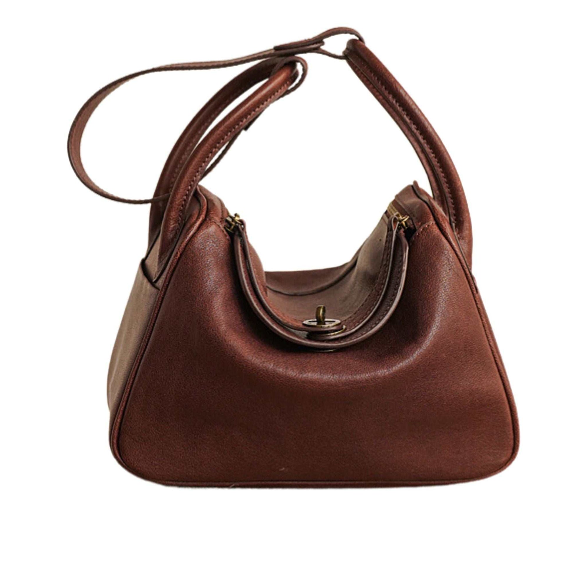 Brown leather satchel purse with adjustable strap and secure double zipper closure.