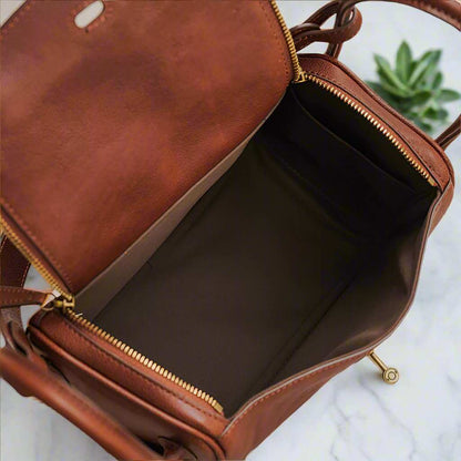 Open leather satchel purse with spacious interior and secure zipper closure.