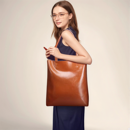 Woman holding a brown leather shoulder bag from the Essence of Elegance Handbag Collection.