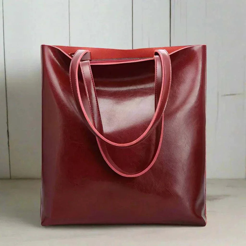 Leather shoulder bag in rich red, crafted from genuine leather, featuring a sleek design suitable for both casual and professional settings.