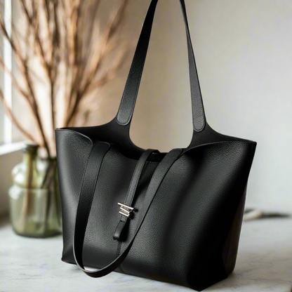 Elegant black leather tote purse with zipper, featuring a unique concave shape, ideal for daily use.