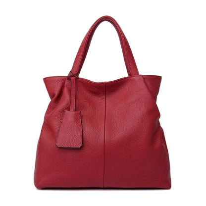 Red leather tote zipper handbag from the Essence of Elegance Collection, featuring a luxurious feel and spacious interior.