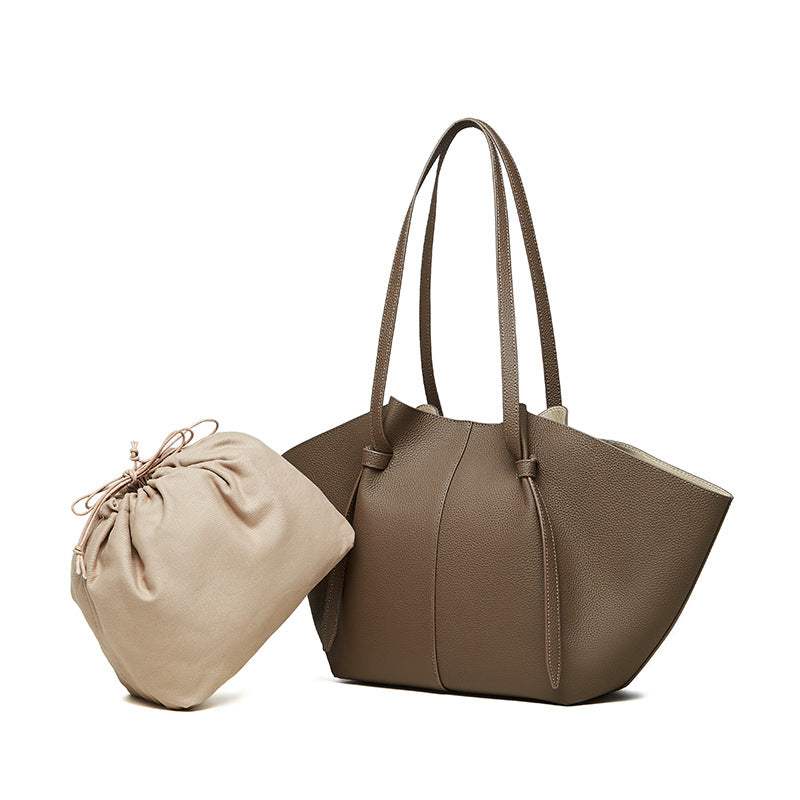 Modern leather work tote with removable drawstring bag, pleated straps, and magnetic closure.