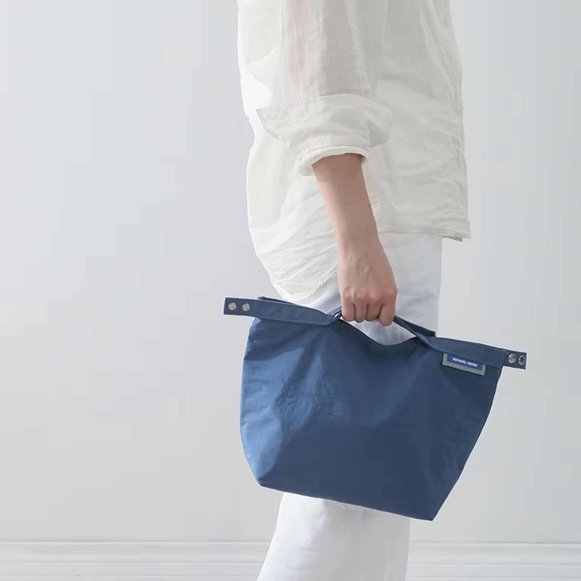 Small lunch bag in elegant blue, water-resistant, thermal insulated, versatile carrying design.