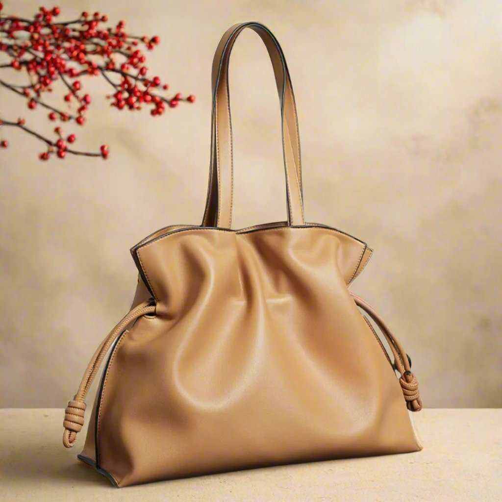 Soft leather tote with pleated exterior, minimalist design, and durable handles.