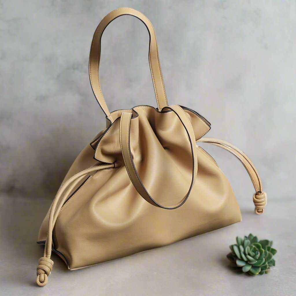 Soft leather tote bag with pleated design and drawstring closure.