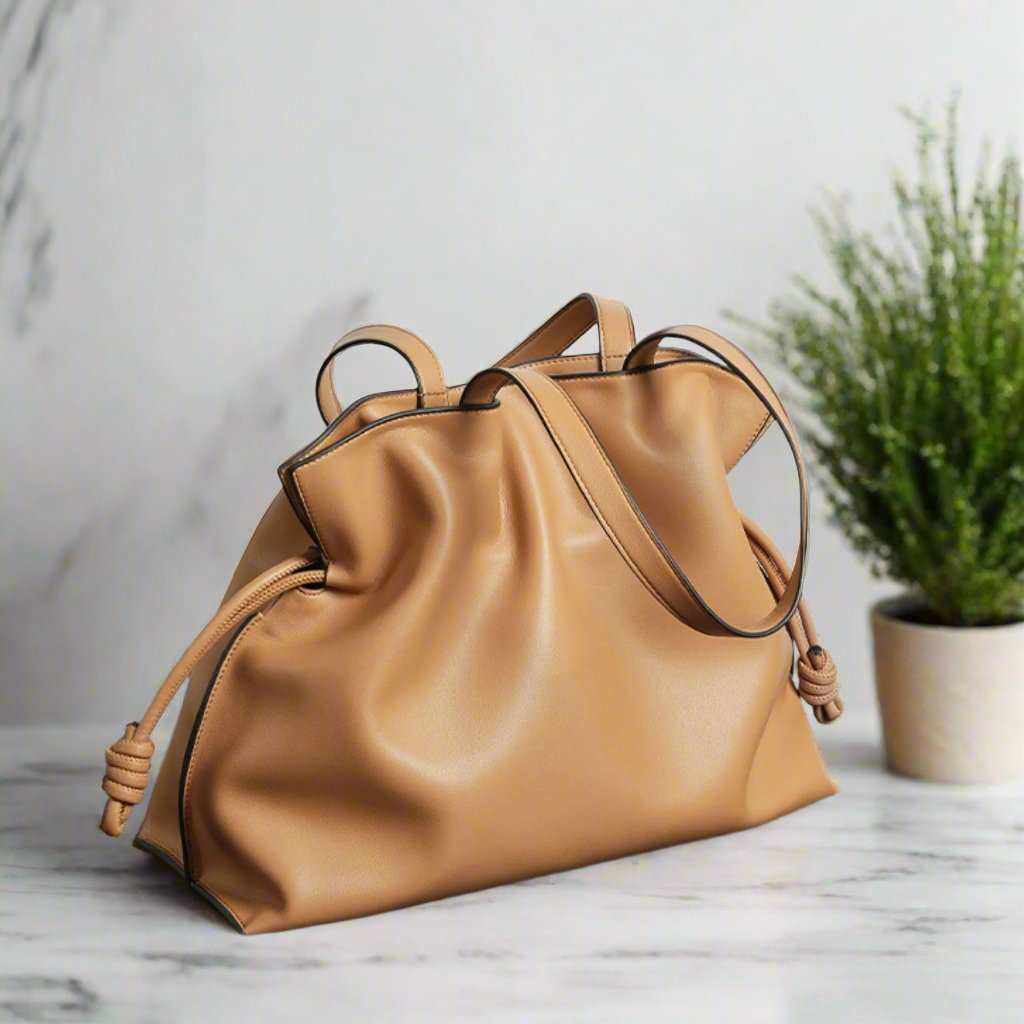 Soft Leather Tote with drawstring closure on marble table, elegant and sophisticated design.