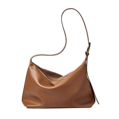 Softest leather handbag with sleek unstructured design and adjustable strap in caramel color.