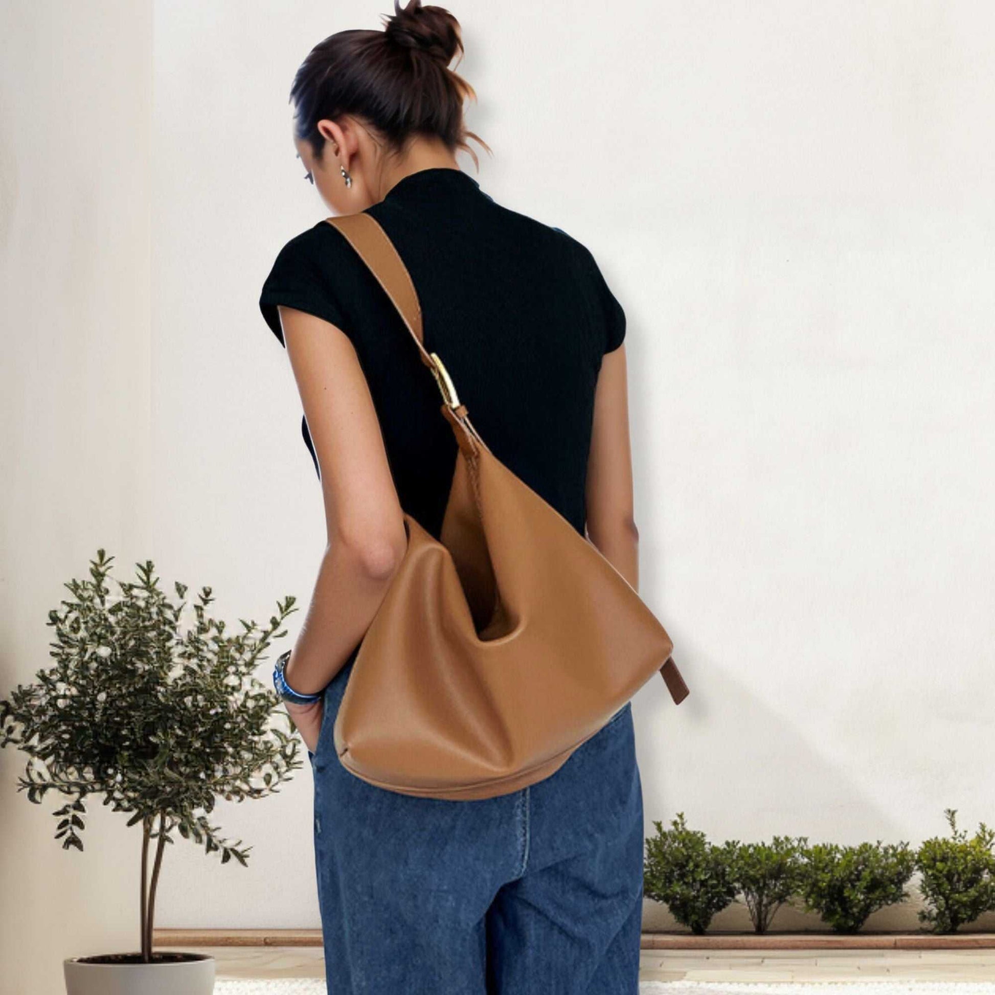 Softest Leather Handbags in caramel color worn as a shoulder bag by a woman, showcasing elegant and practical design.