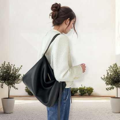 Woman carrying Softest Leather Handbags in black, showcasing a sophisticated and versatile design.