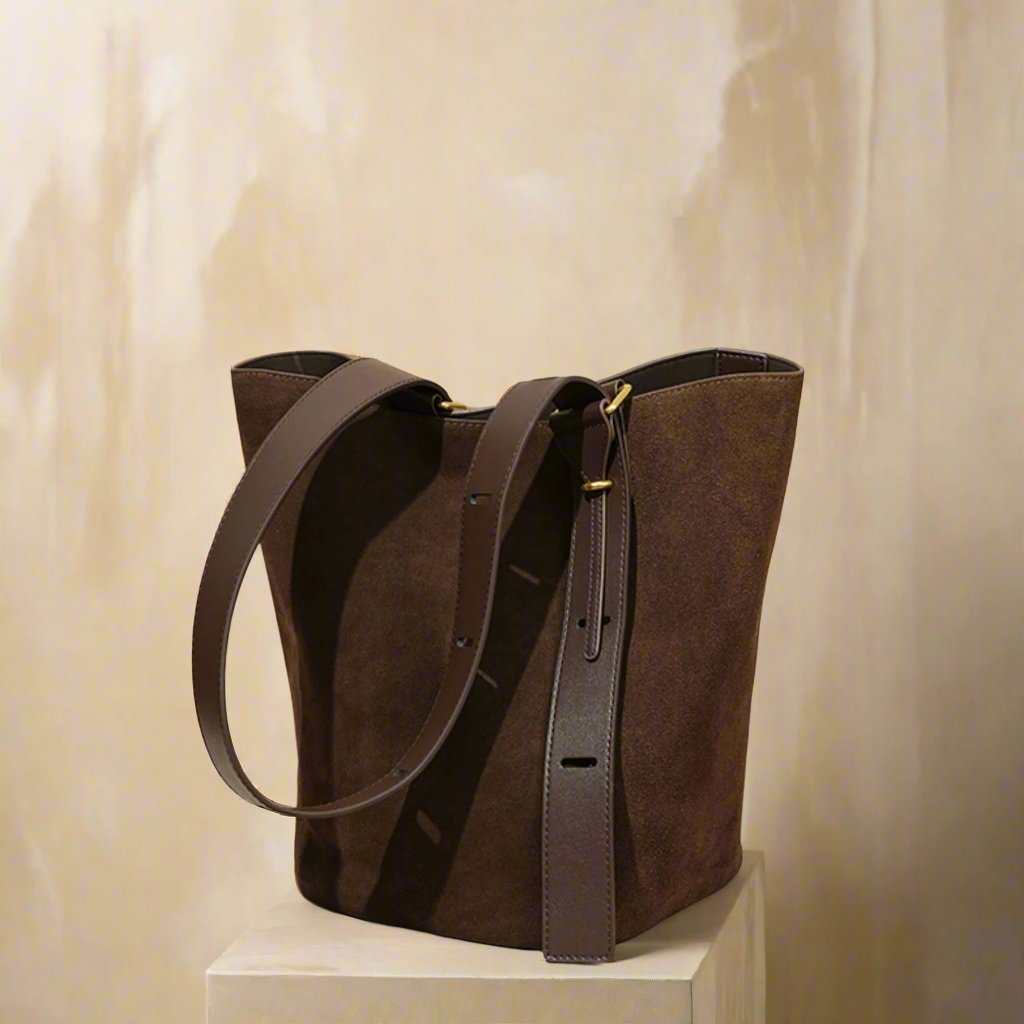 Suede bucket bag on display, featuring durable nubuck leather, convertible design, and spacious interior.