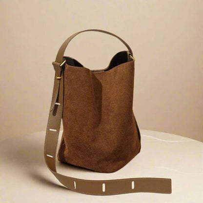 Suede bucket bag with adjustable strap and versatile design, crafted from nubuck leather.